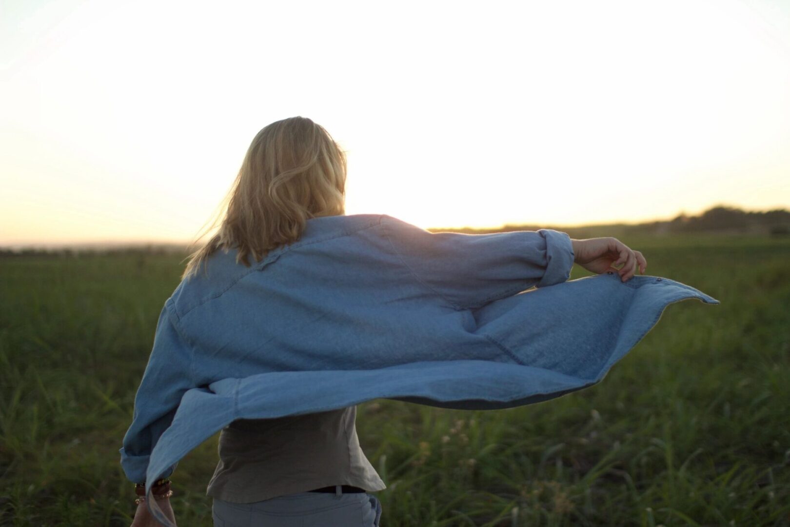 A woman holding onto the wind in her shirt