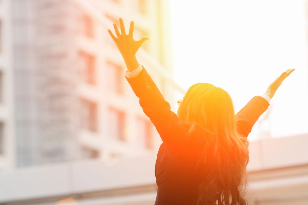 A woman with her arms raised in the air.